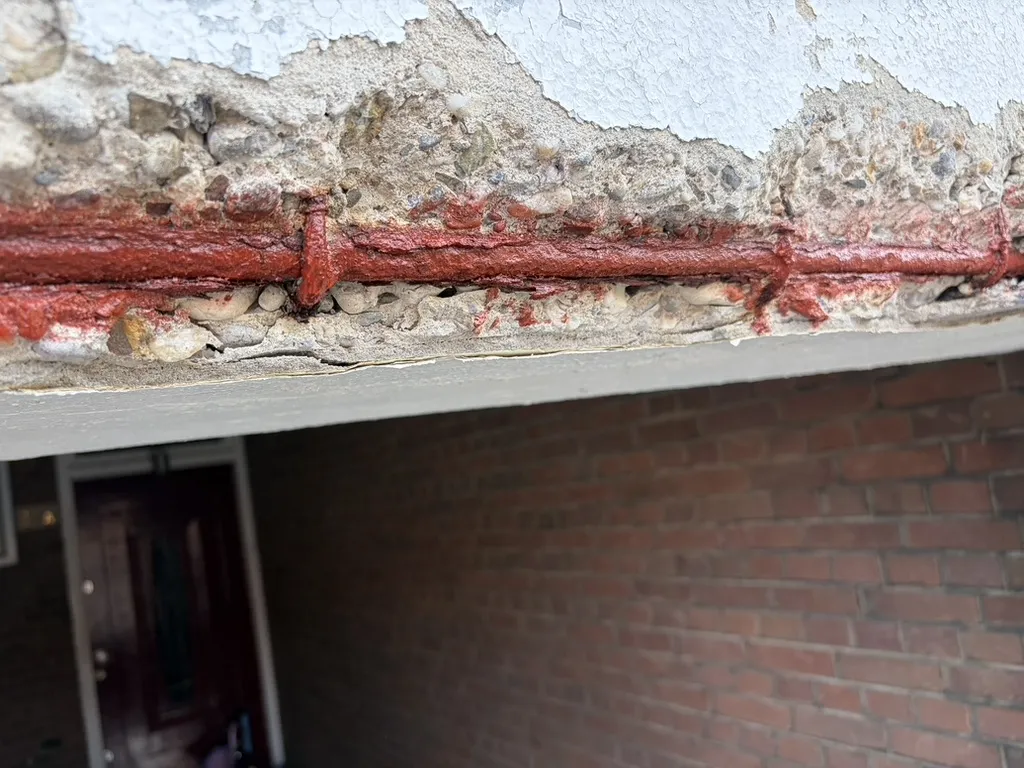 Betonreparatie Schiedam — voorsituatie: betonrot met verroest staal, behandeld met rode anti-roestcoating