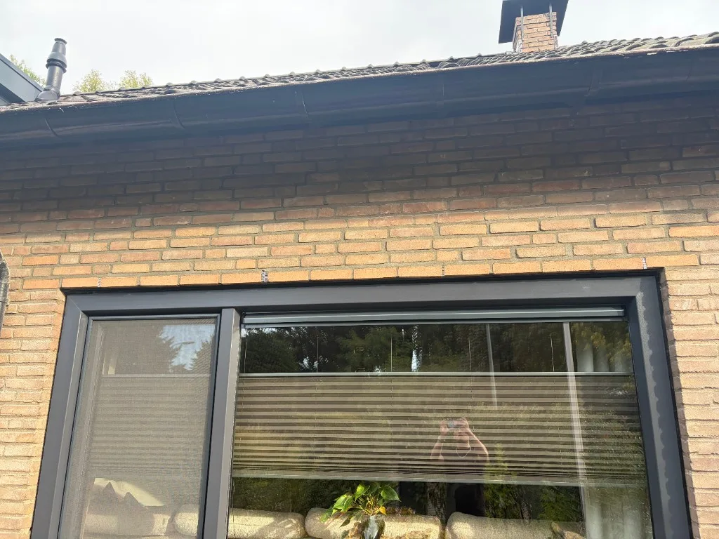 Detail hersteld metselwerk boven kozijn — geveldragers zichtbaar in voeg, strak afgewerkt