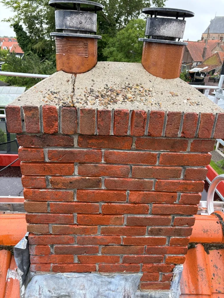 Dezelfde schoorsteen na reiniging met schone rode baksteen