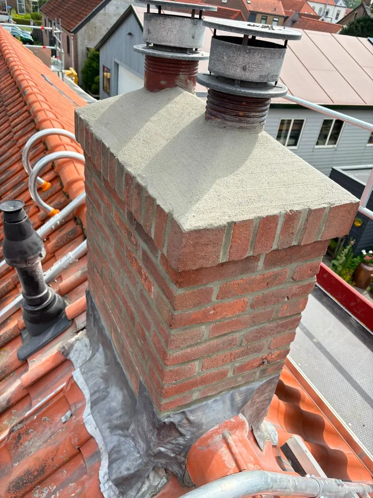 Schoorsteen na renovatie met strak nieuw voegwerk en herstelde betonnen afdekvloer