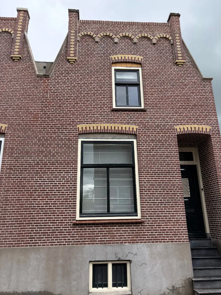 Detail snijvoeg en sierdetails boven kozijn na gevelrevisie