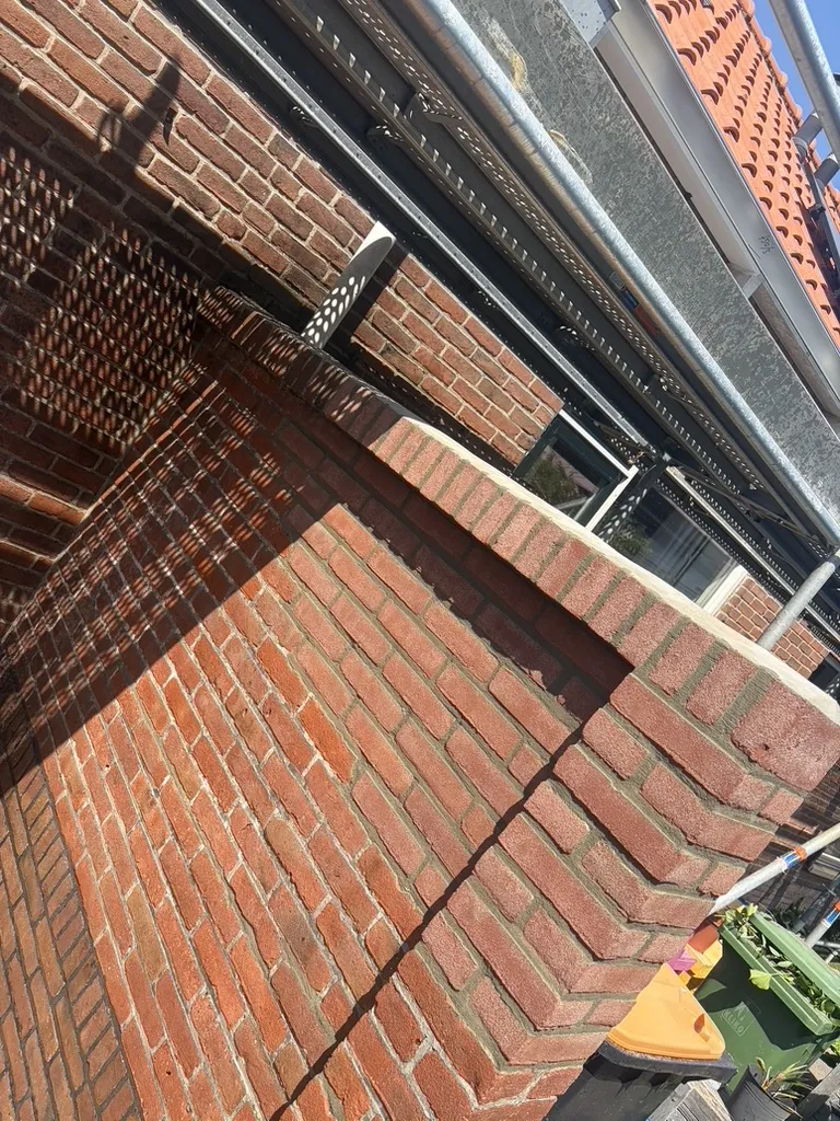 Opnieuw gemetselde tuinmuur in Brouwershaven met platvol voegwerk, rollaag en aangesmeerd betonnen dakje